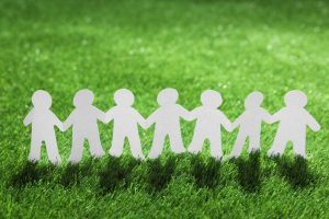 paper people chain green grass unity concept